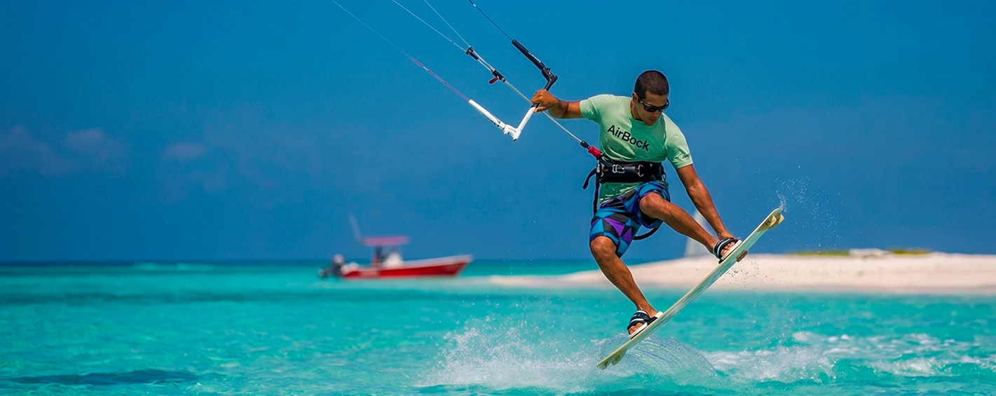 Kitesurfer jumping over turquoise ocean